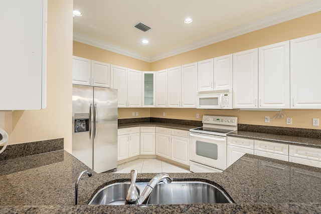 kitchen featuring recessed lighting, a sink, dark stone countertops, visible vents, and white appliances