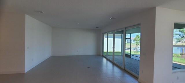 unfurnished room with a wealth of natural light and tile patterned flooring