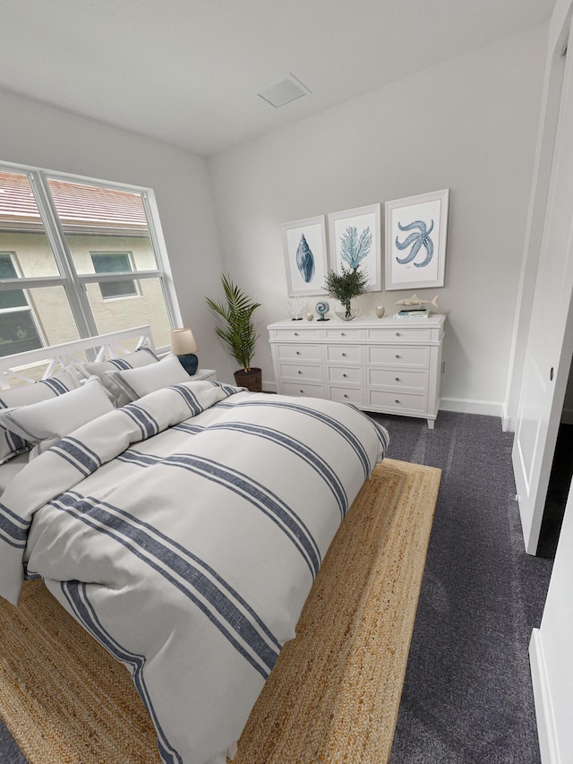 bedroom featuring dark carpet and baseboards