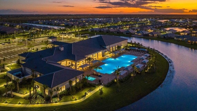 aerial view at dusk featuring a water view