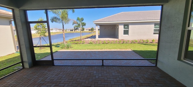 unfurnished sunroom featuring a residential view and a water view