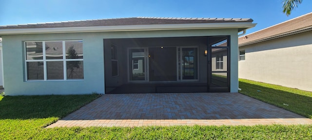 doorway to property featuring a patio area and a yard