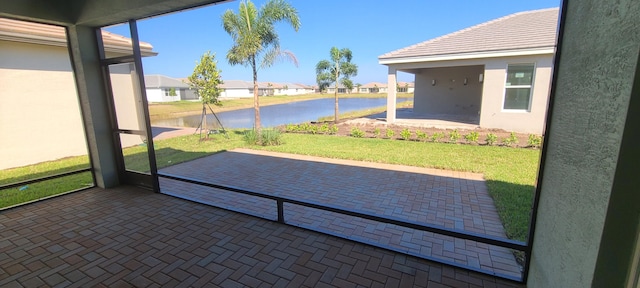 unfurnished sunroom with a residential view and a water view