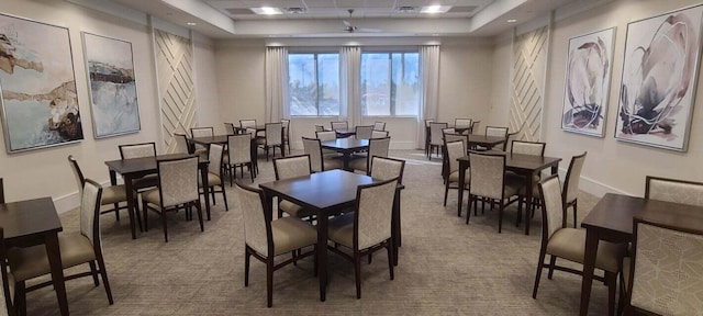 dining area featuring carpet flooring and a raised ceiling