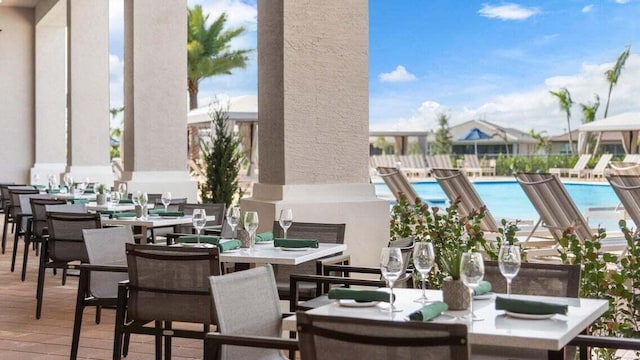 view of patio featuring a community pool and outdoor dining area