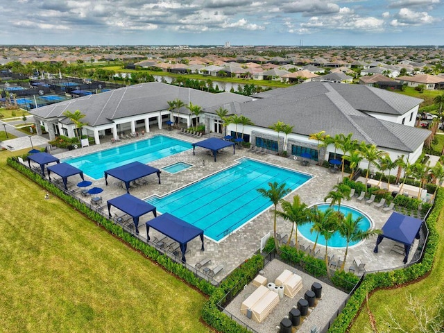 community pool with a residential view, a lawn, and a patio