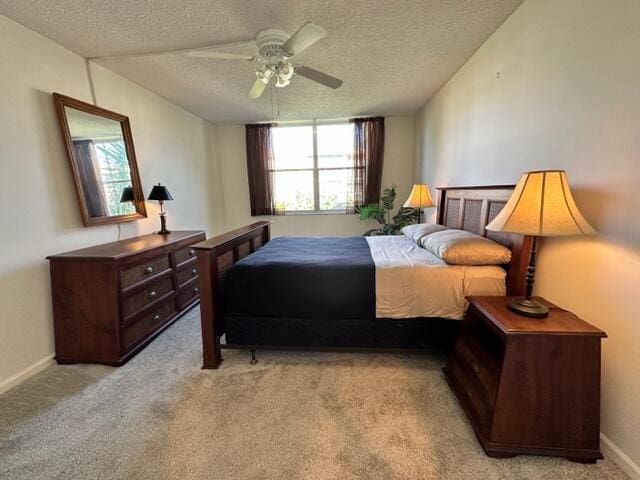 bedroom with light colored carpet, ceiling fan, a textured ceiling, and baseboards