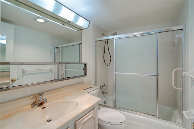 bathroom with toilet, shower / bath combination with glass door, and vanity