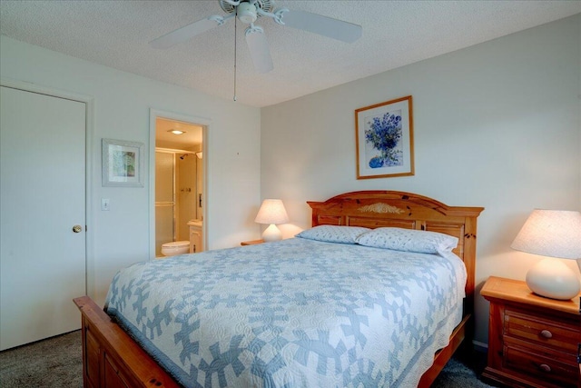 bedroom featuring a textured ceiling, ceiling fan, dark colored carpet, and ensuite bathroom