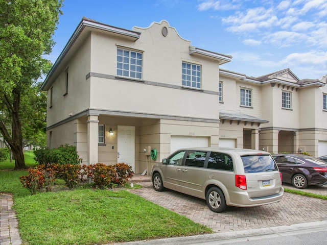 view of property featuring a front yard and a garage