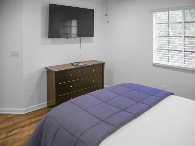 bedroom with dark hardwood / wood-style floors