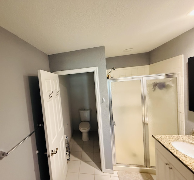 bathroom with a shower with door, tile patterned flooring, vanity, a textured ceiling, and toilet