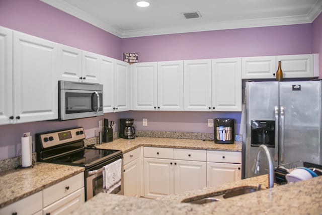 kitchen featuring appliances with stainless steel finishes, crown molding, and white cabinetry