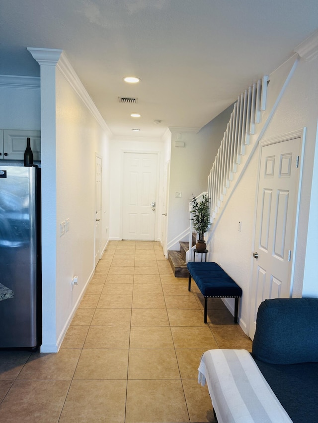 hall featuring crown molding and light tile patterned flooring