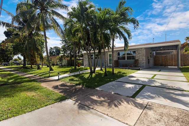 ranch-style home with a carport and a front lawn