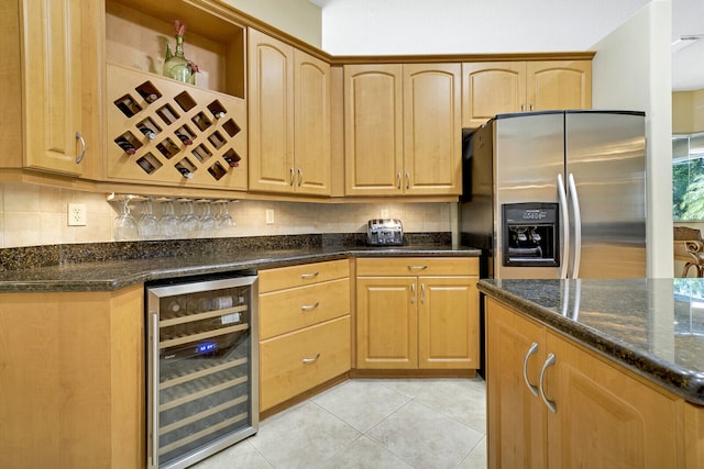 kitchen featuring wine cooler, stainless steel fridge with ice dispenser, backsplash, dark stone counters, and light tile patterned floors