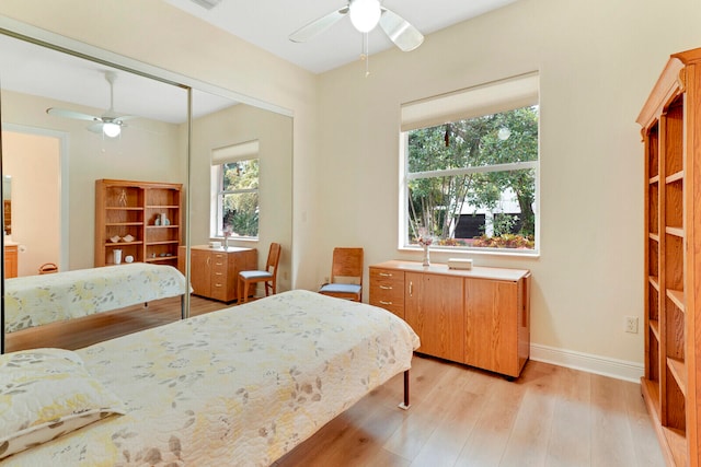 bedroom featuring light wood-type flooring, a closet, and ceiling fan