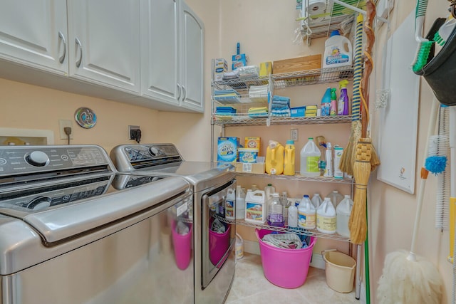 washroom with cabinets, light tile patterned floors, and washing machine and clothes dryer