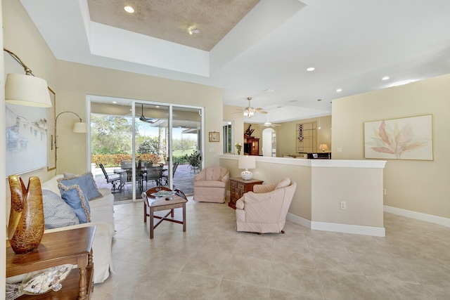 tiled living room featuring a raised ceiling