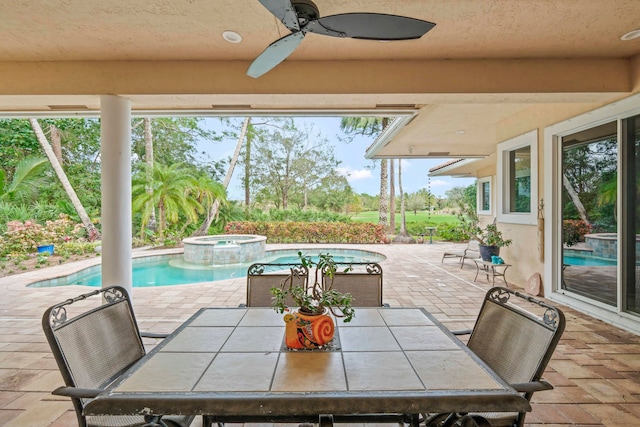 view of patio featuring ceiling fan and a swimming pool with hot tub