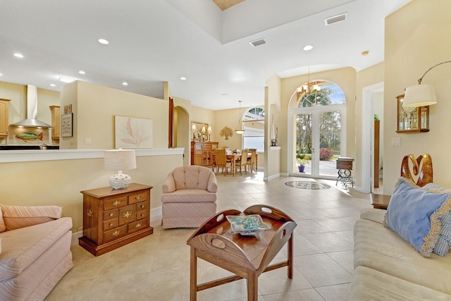 living room with light tile patterned flooring, french doors, and a chandelier