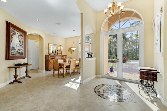 entryway featuring french doors, light tile patterned floors, and a notable chandelier