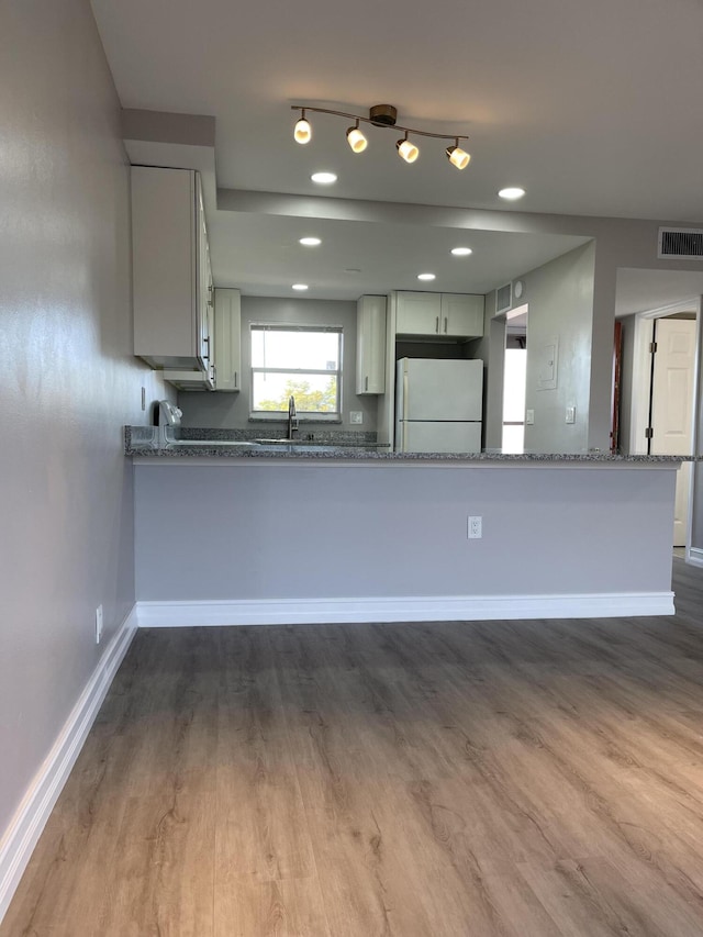 kitchen featuring visible vents, freestanding refrigerator, baseboards, and dark wood-style floors