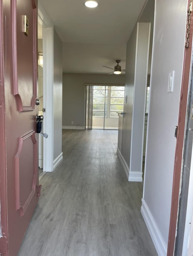 hall featuring baseboards and wood finished floors