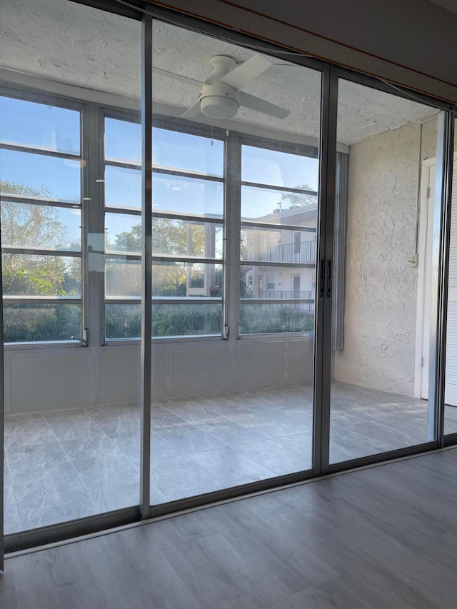 doorway to outside featuring ceiling fan, hardwood / wood-style floors, and a healthy amount of sunlight