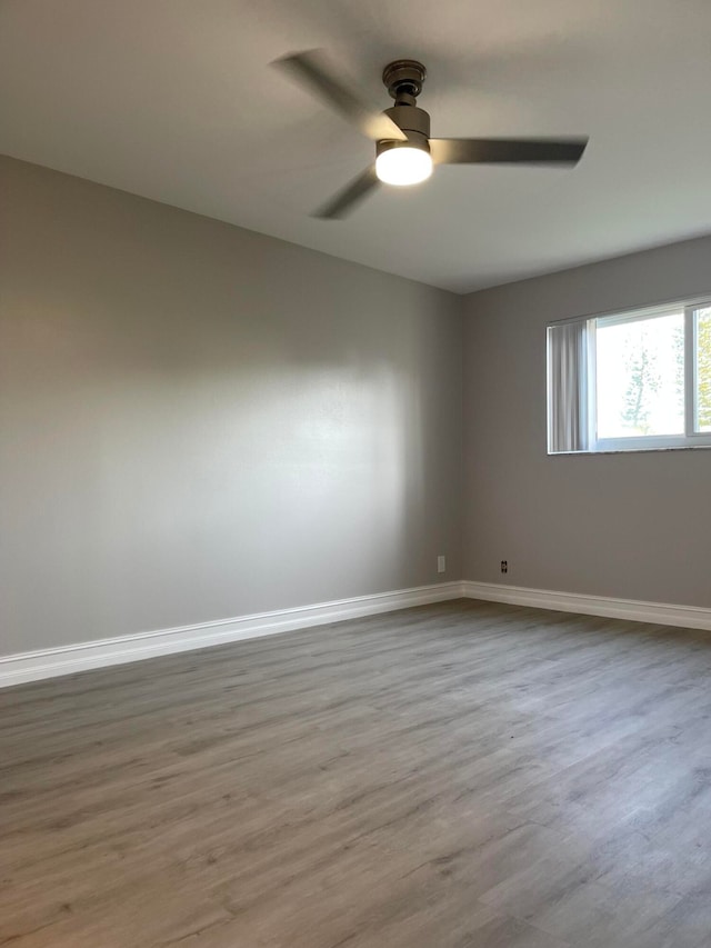 spare room with hardwood / wood-style floors and ceiling fan