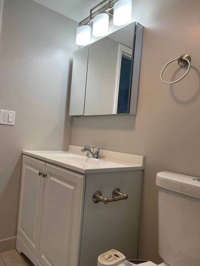 bathroom with tile patterned flooring, vanity, and toilet