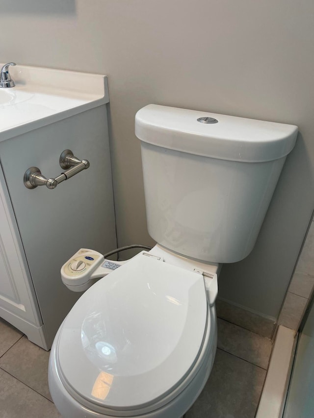 bathroom with tile patterned flooring, vanity, and toilet