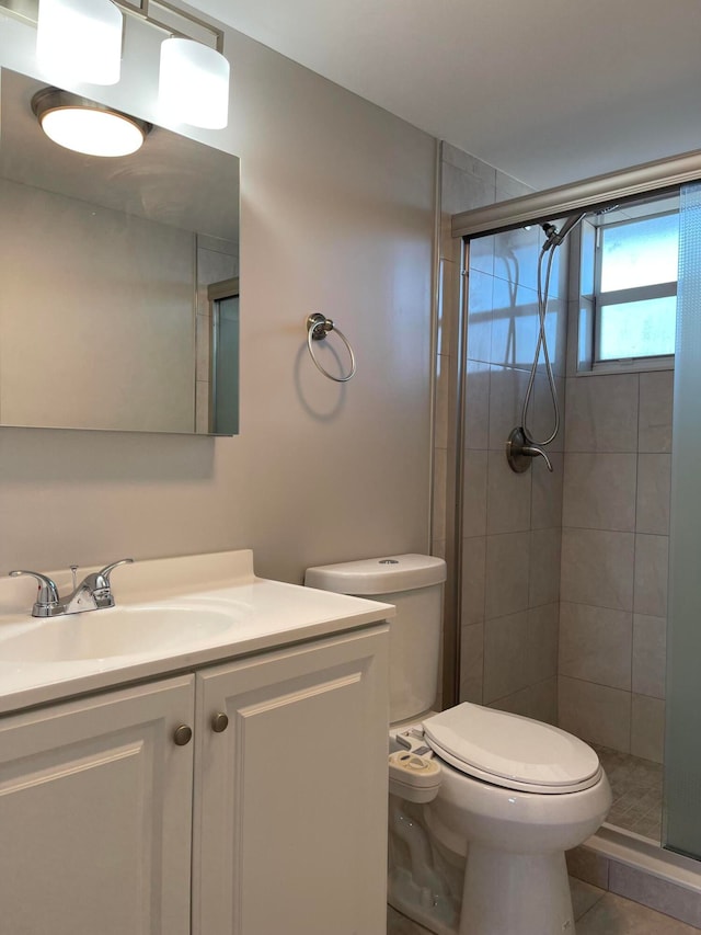 bathroom with walk in shower, vanity, tile patterned flooring, and toilet