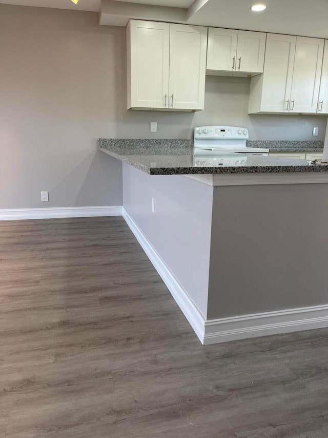 kitchen featuring range, dark stone countertops, white cabinetry, and dark hardwood / wood-style floors