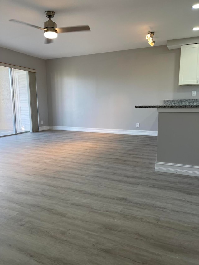 unfurnished living room with wood-type flooring and ceiling fan