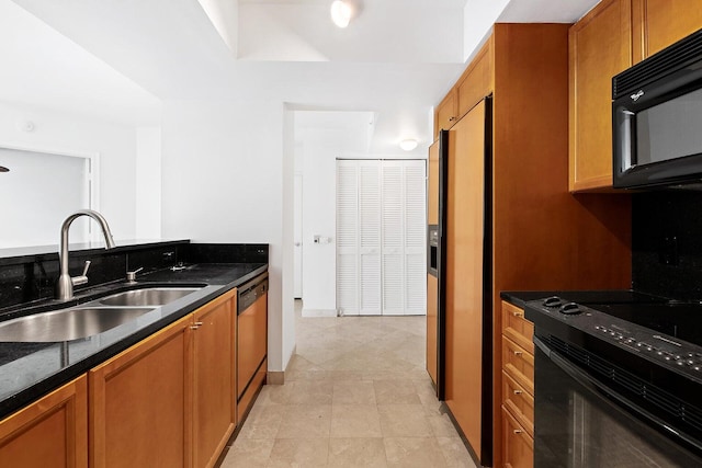 kitchen featuring dark stone counters, sink, and black appliances