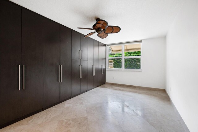 unfurnished bedroom featuring ceiling fan, a textured ceiling, and a closet