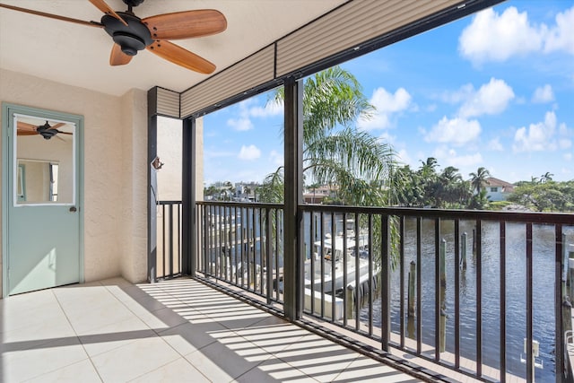 balcony with ceiling fan and a water view