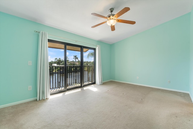 unfurnished room featuring carpet flooring, a water view, and ceiling fan