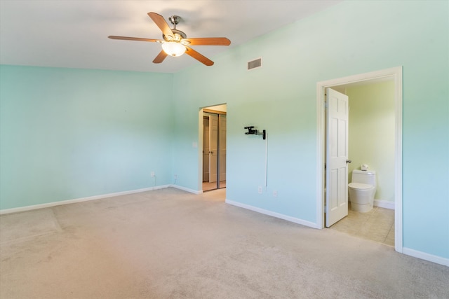 unfurnished bedroom featuring connected bathroom, ceiling fan, a closet, and light carpet