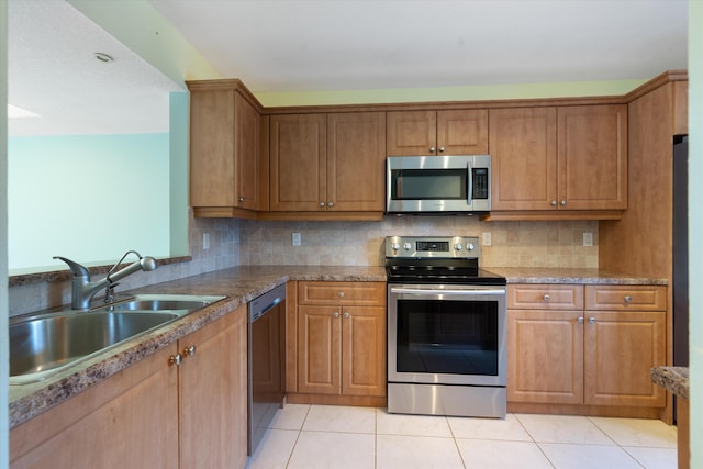 kitchen featuring light tile patterned floors, backsplash, stainless steel appliances, and sink