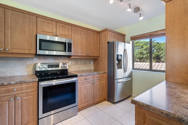 kitchen featuring appliances with stainless steel finishes, backsplash, and light tile patterned floors