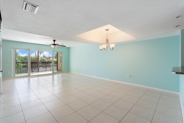 tiled empty room with a tray ceiling, a textured ceiling, and ceiling fan with notable chandelier