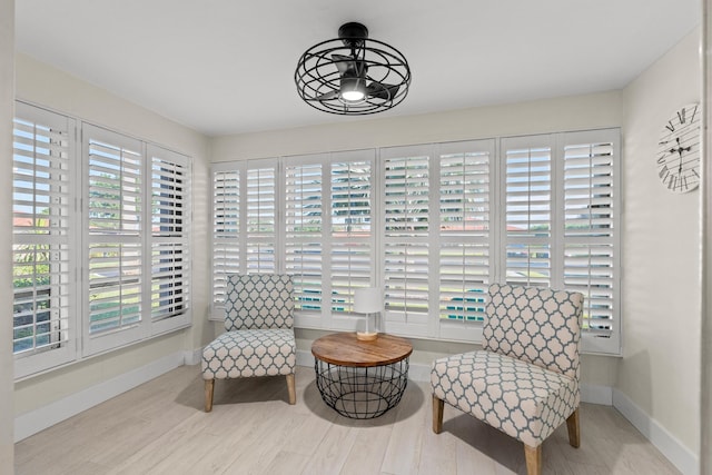 living area featuring ceiling fan, light wood-type flooring, and a wealth of natural light