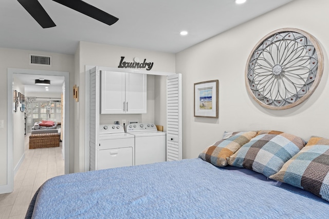 bedroom with light hardwood / wood-style floors, ceiling fan, and washing machine and dryer