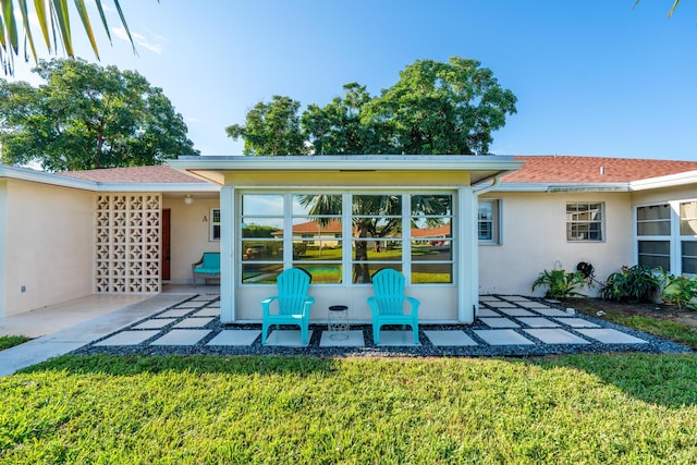 rear view of property featuring a patio and a yard