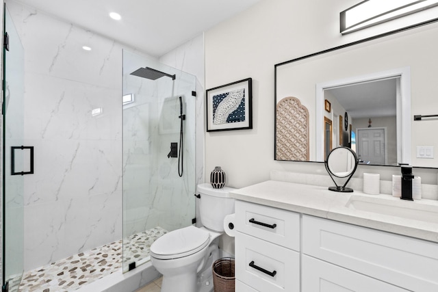 bathroom with vanity, a shower with shower door, and toilet