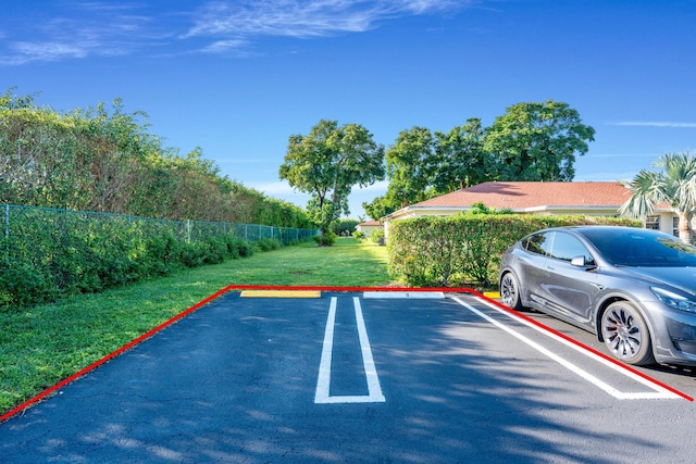 view of parking / parking lot featuring a yard