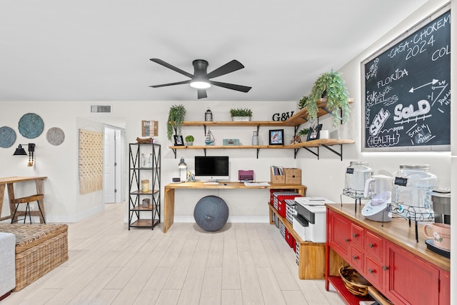 office space featuring light hardwood / wood-style flooring, built in desk, and ceiling fan