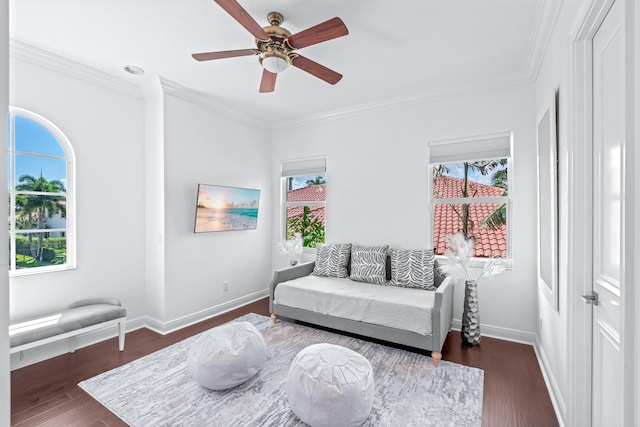 sitting room with ceiling fan, ornamental molding, and dark wood-type flooring